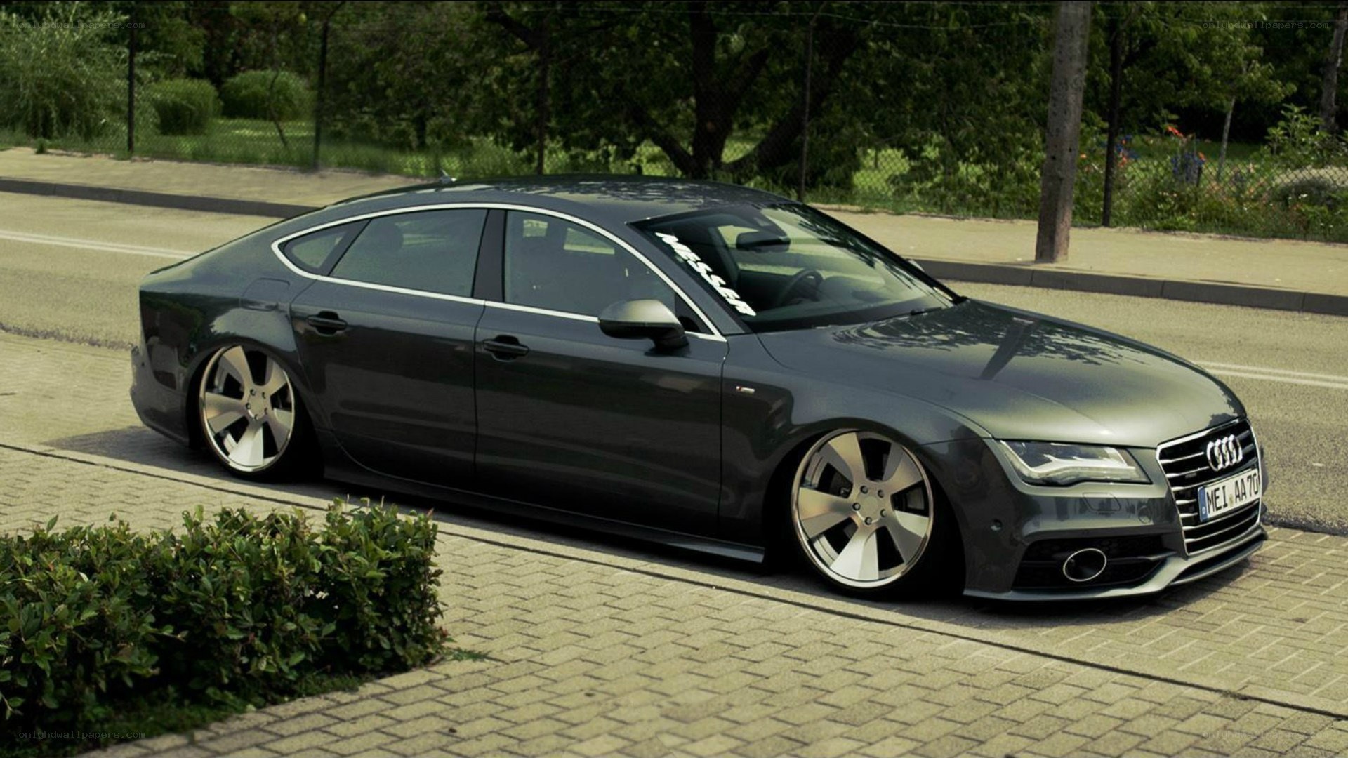 Dark gray Audi A7 parked on sidewalk
