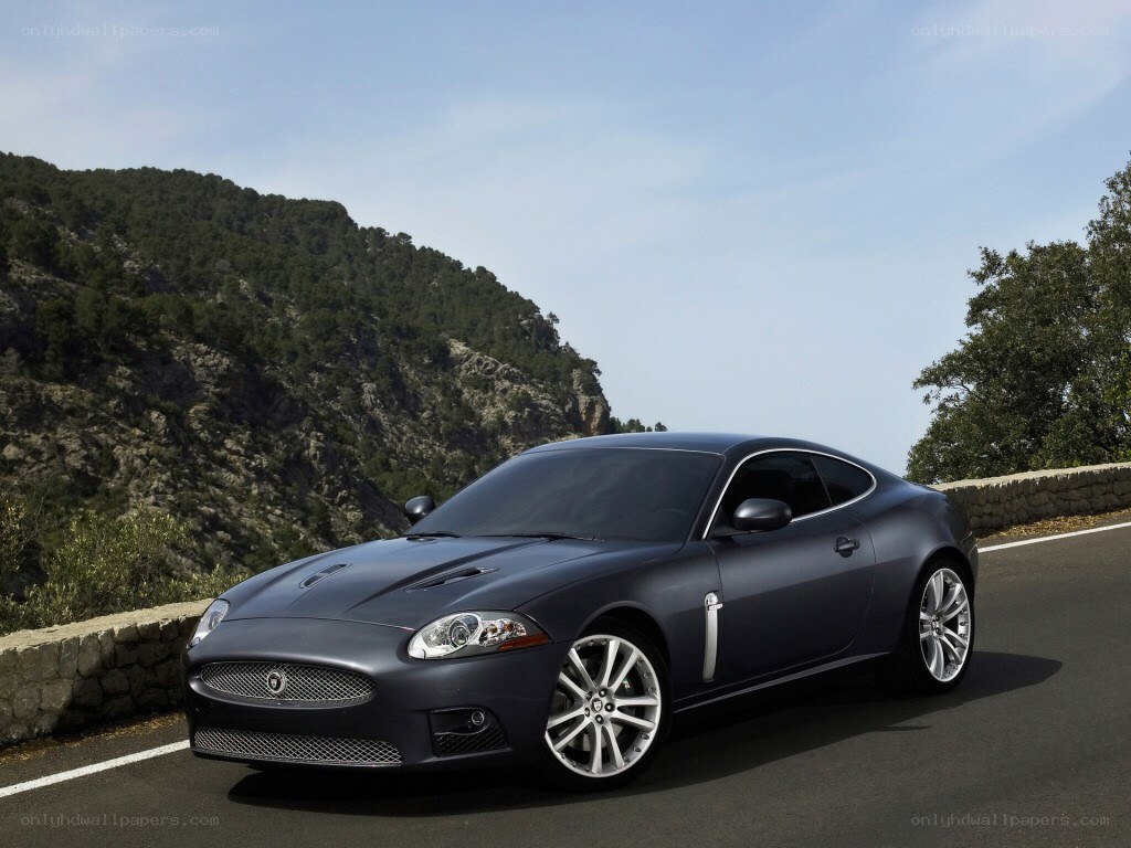 Dark gray Jaguar coupe on mountain road