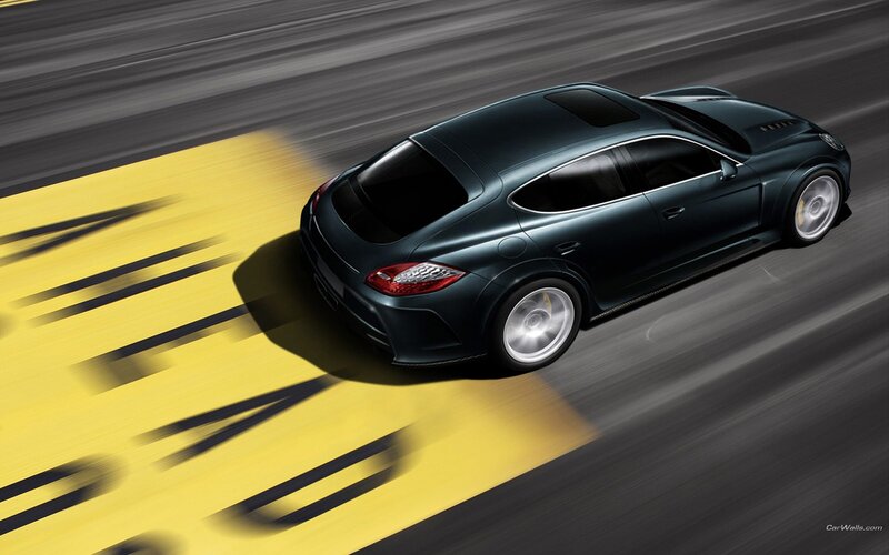 Dark green sports car in motion