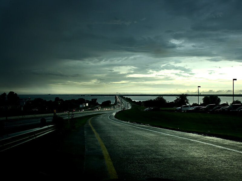 Dark highway over water at dusk