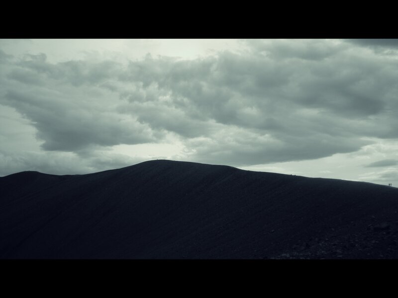 dark hill under cloudy sky