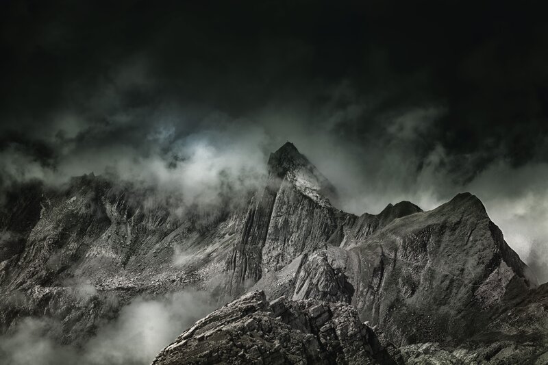 Dark mountain peak shrouded in clouds