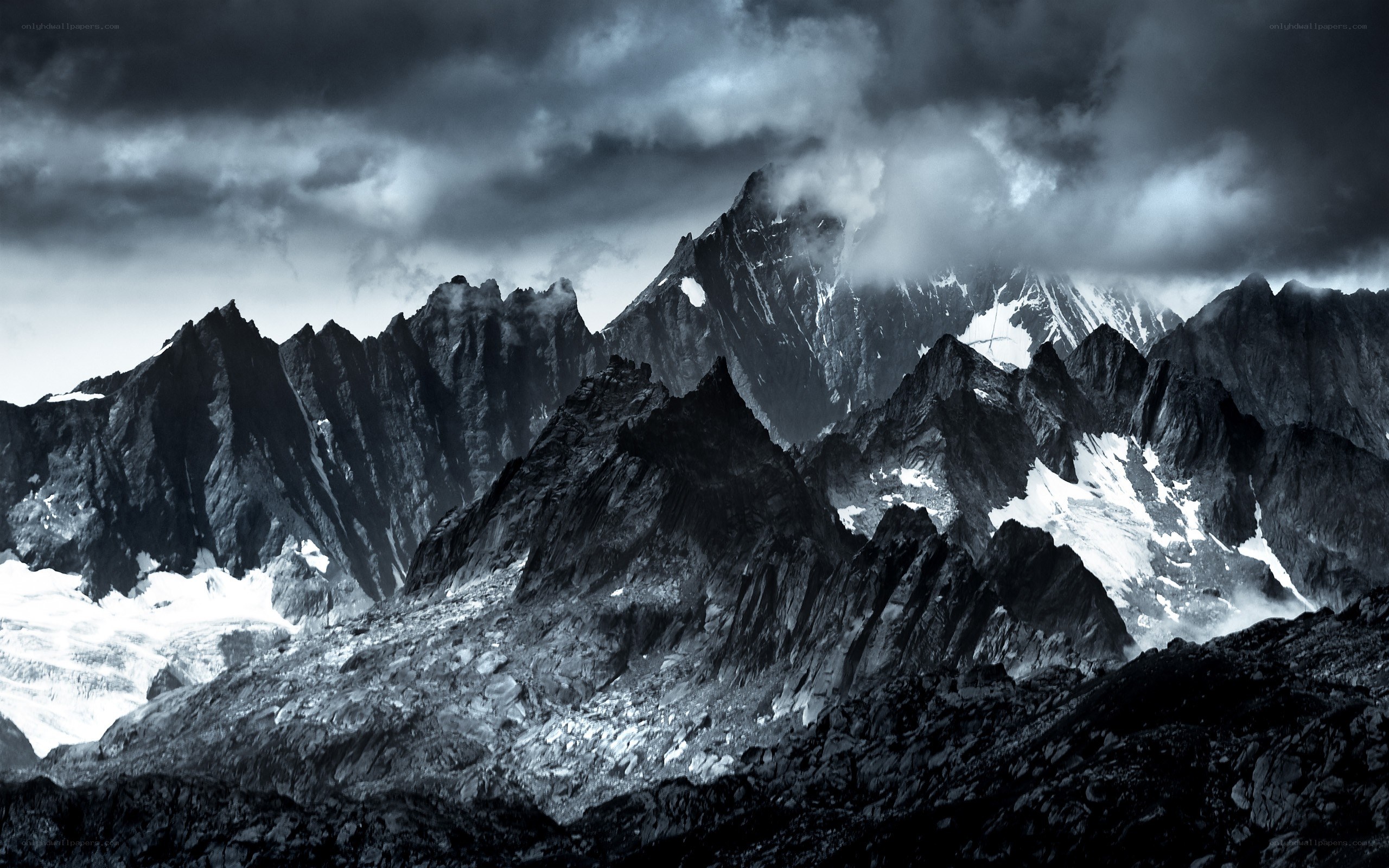 Dark mountain peaks under stormy sky