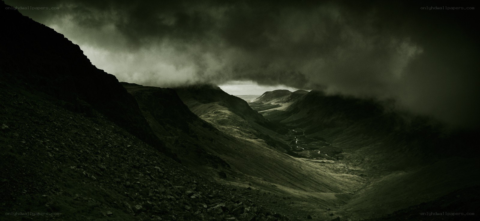 Dark mountain valley under stormy sky