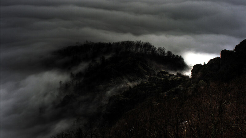Dark mountains under stormy sky