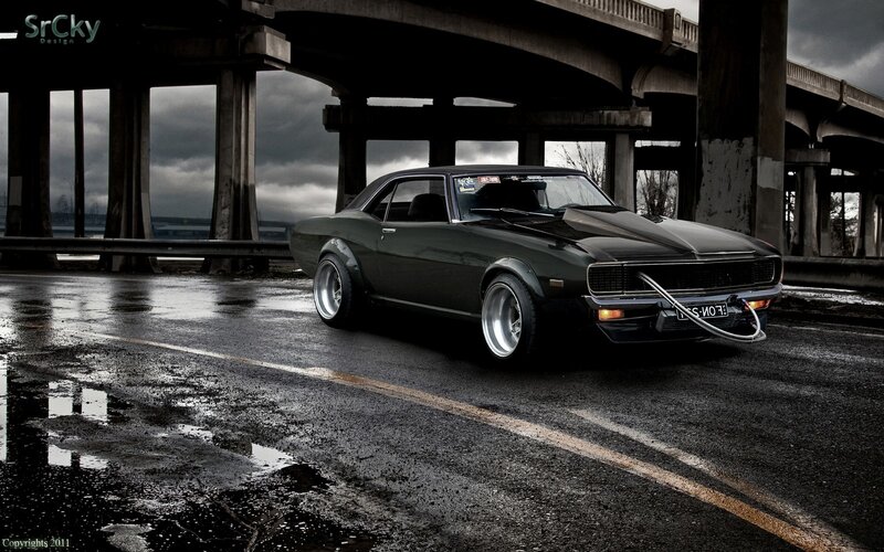 Dark muscle car under bridge