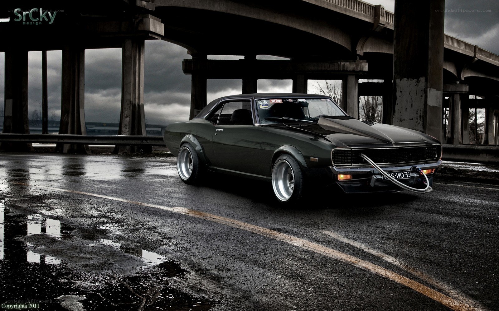 Dark muscle car under bridge