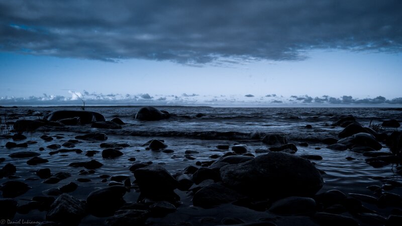 Dark rocky shoreline at dusk
