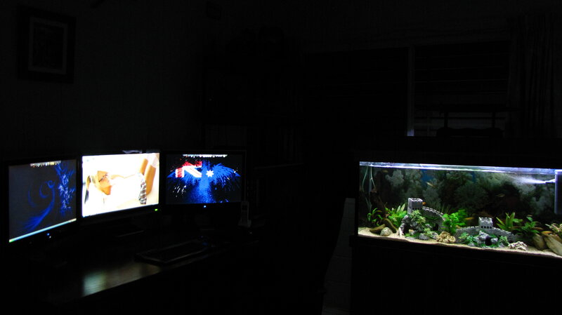 dark room with monitors and fish tank