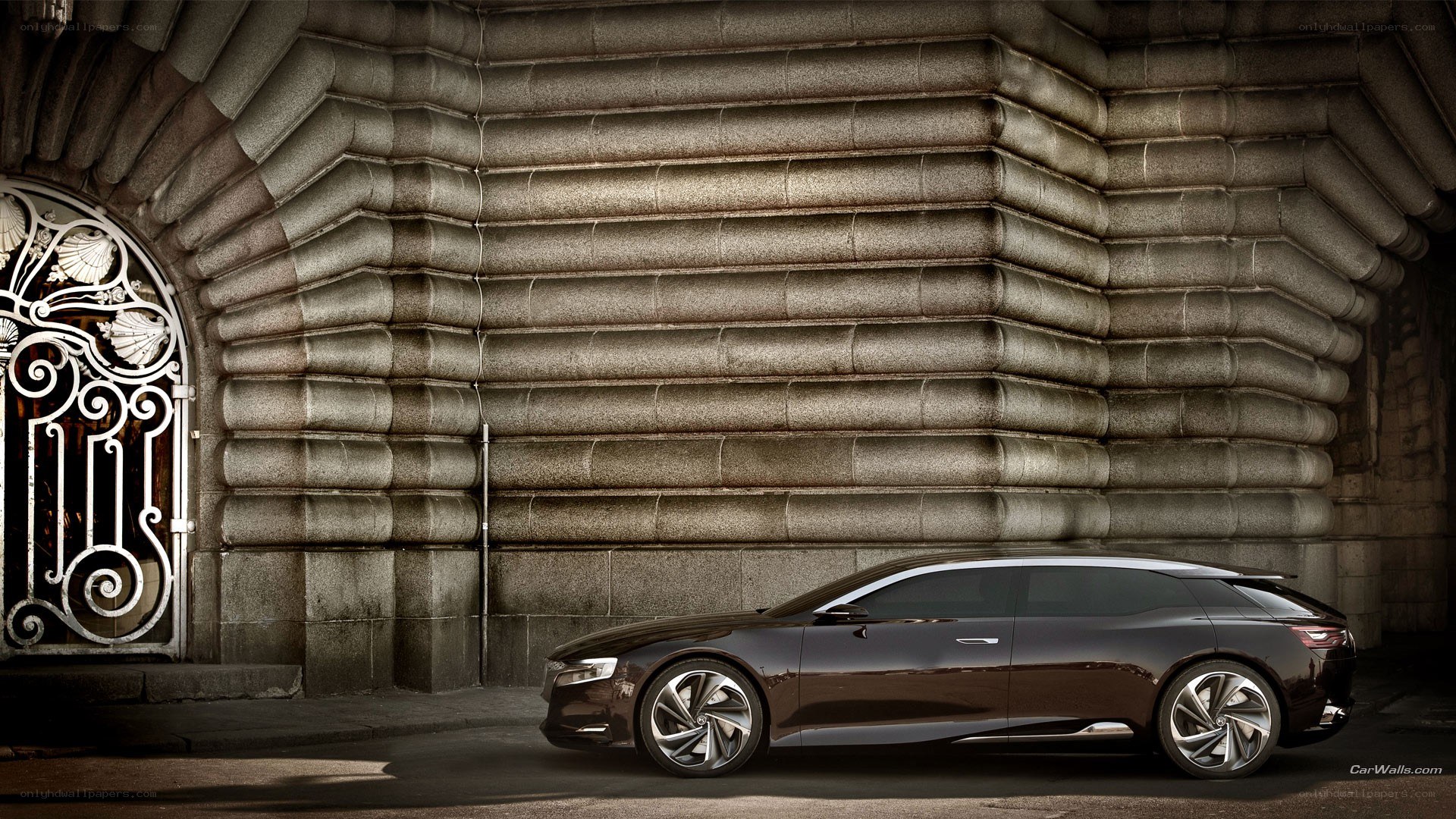 Dark sedan by stone wall