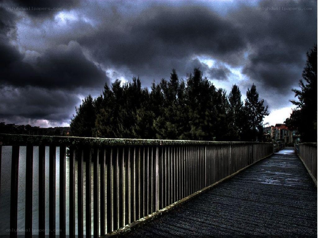 Dark sky over a wooden bridge