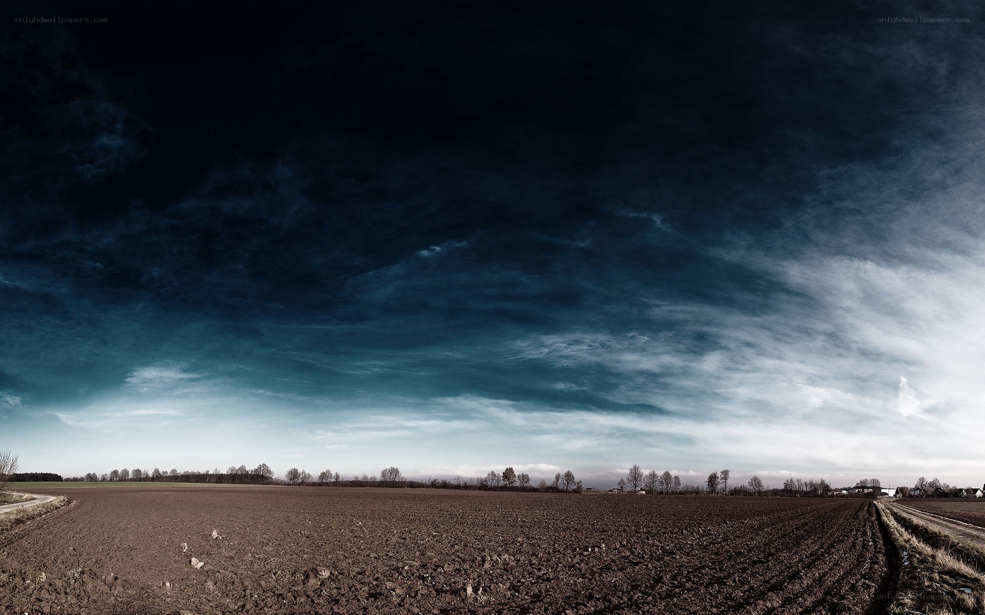 Dark sky over plowed field
