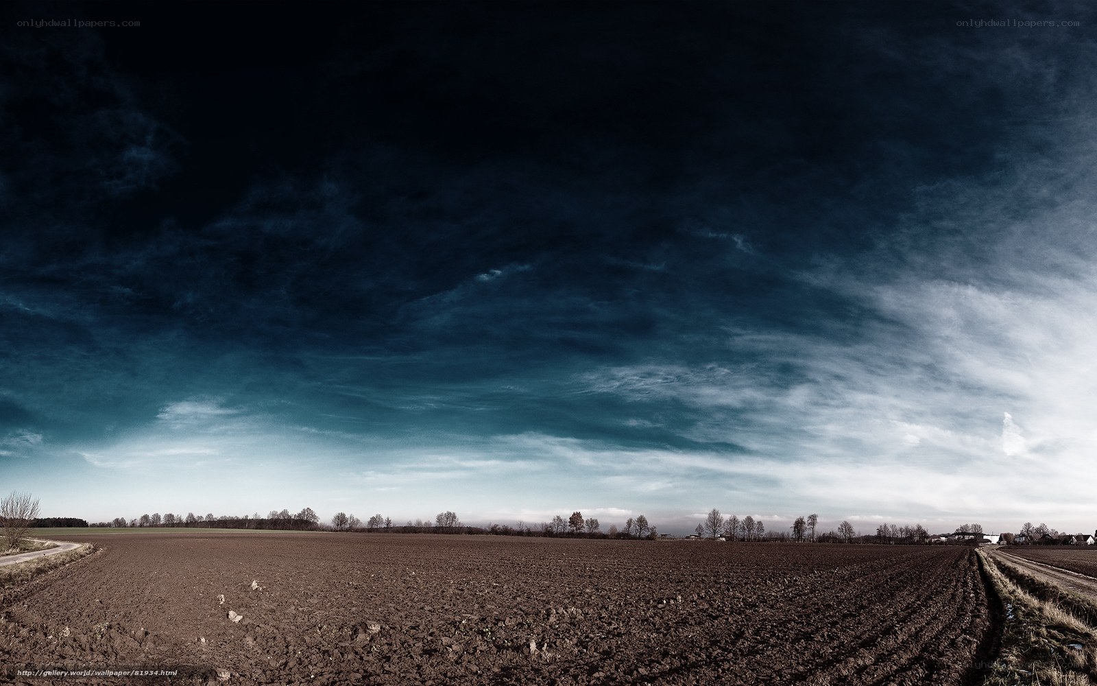 Dark sky over plowed field