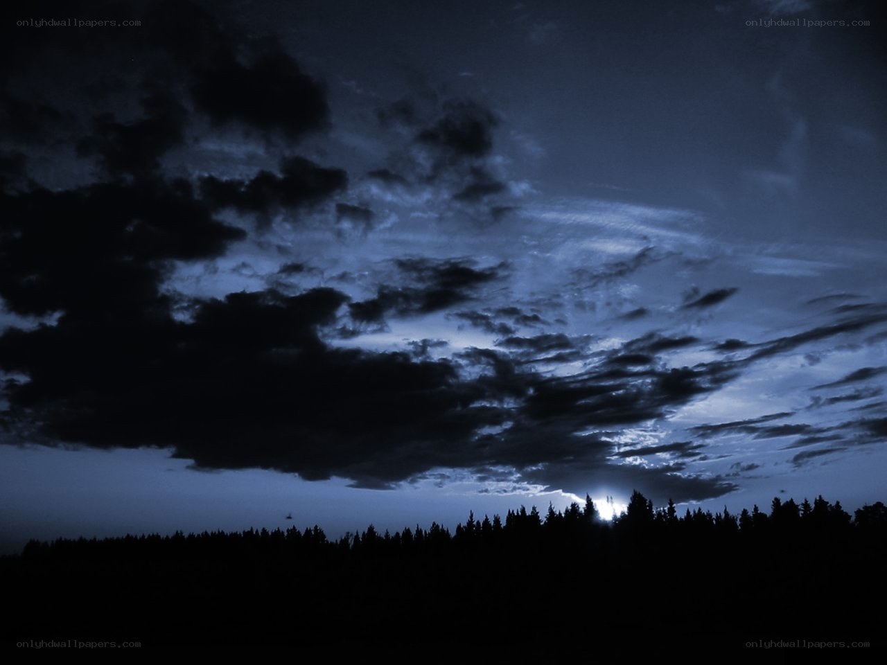 Dark sky with clouds and trees