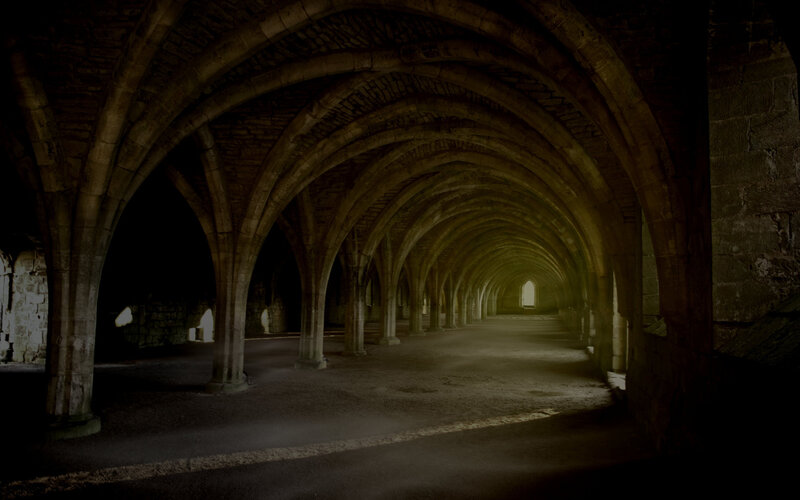 Dark stone corridor with arches