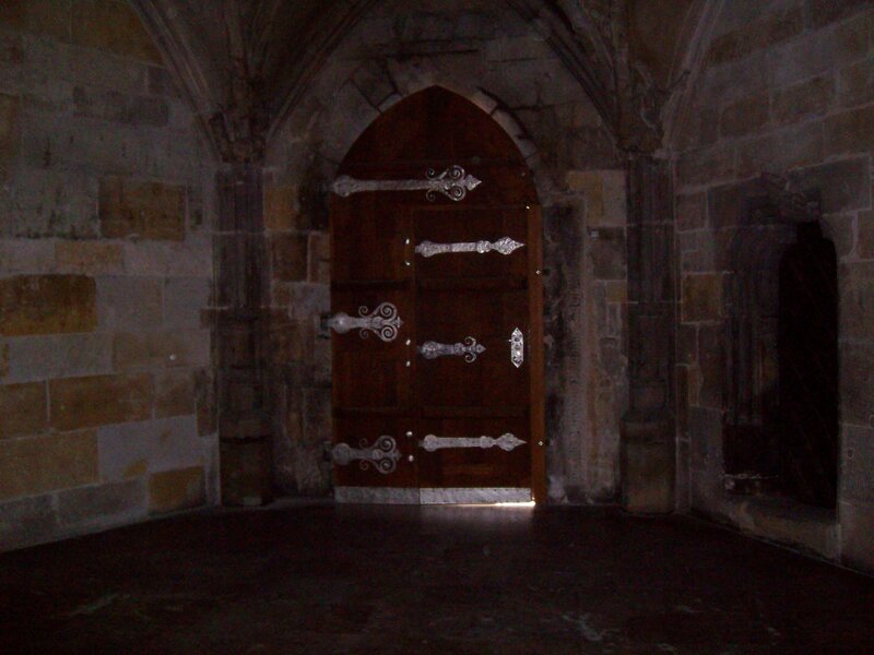 Dark stone hallway with wooden door