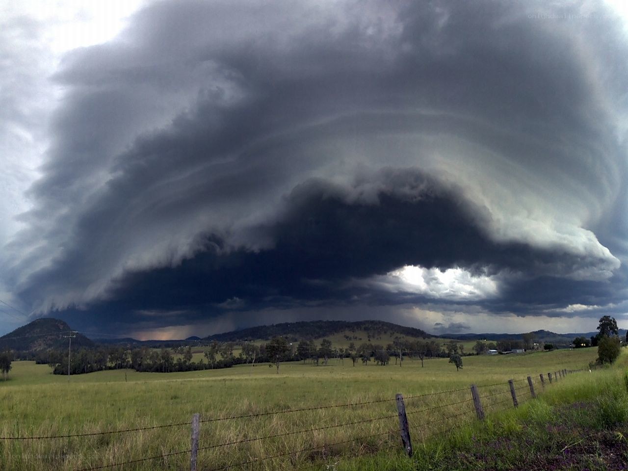 Dark storm cloud over rural landscape