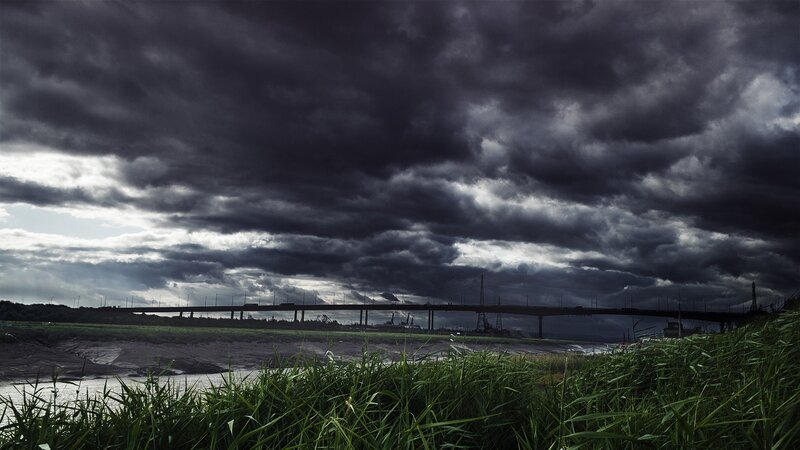 Dark storm clouds over a bridge