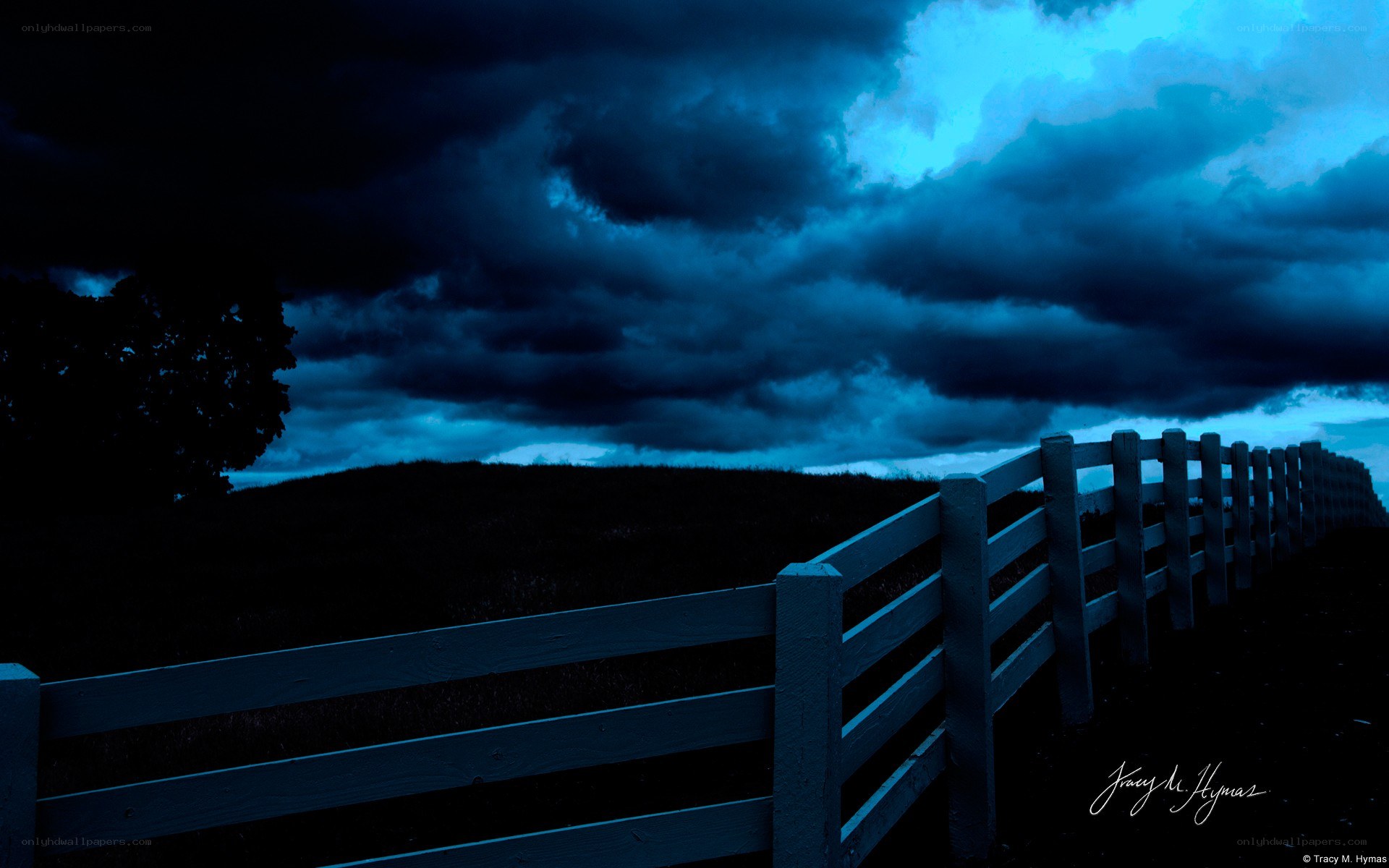 Dark storm clouds over a fence