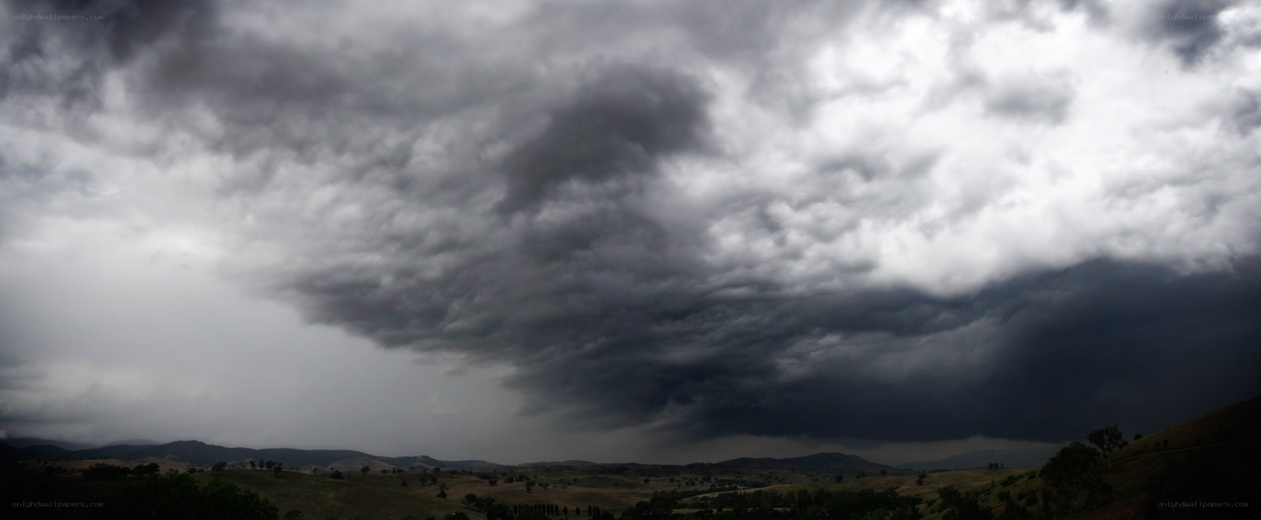 Dark storm clouds over hills