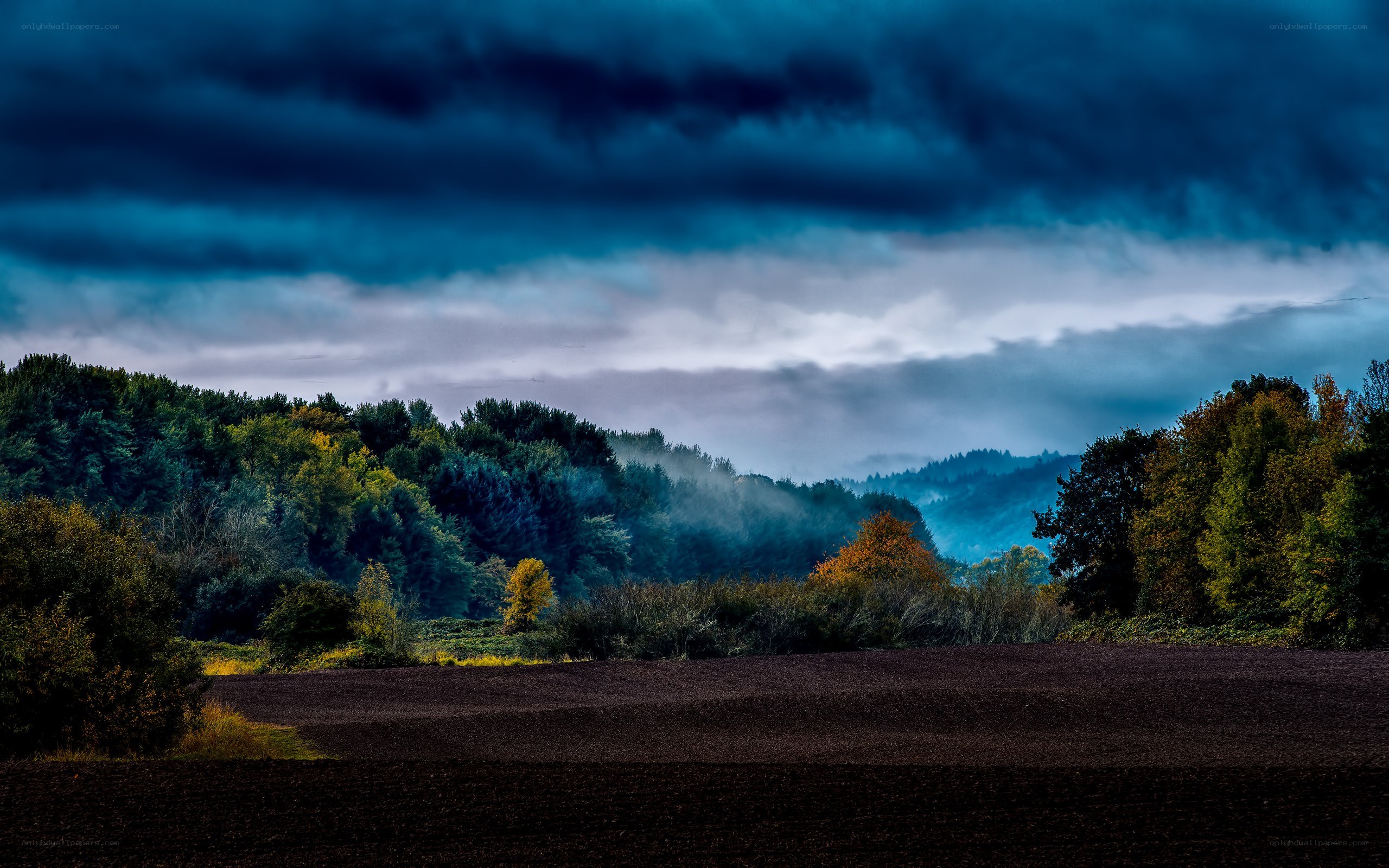 Dark storm over a plowed field