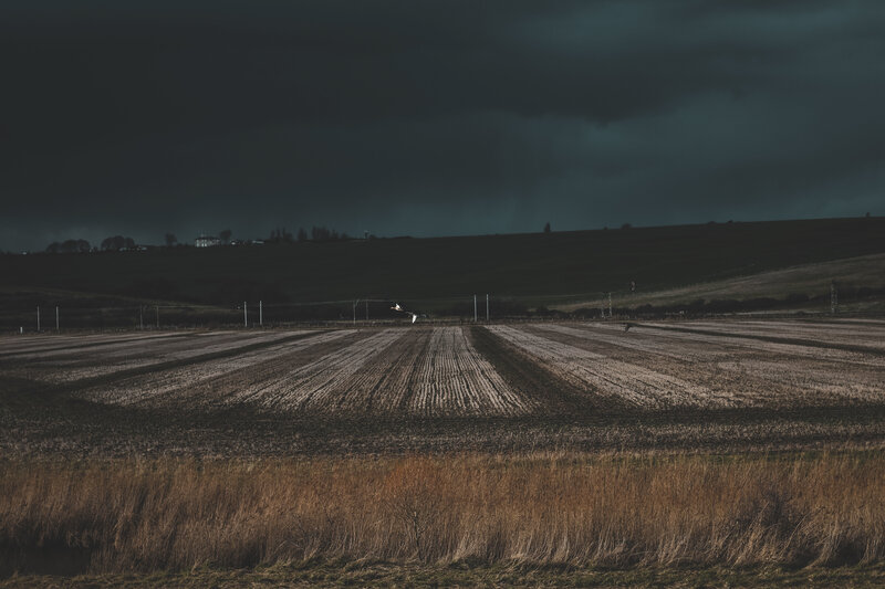 Dark storm over plowed fields
