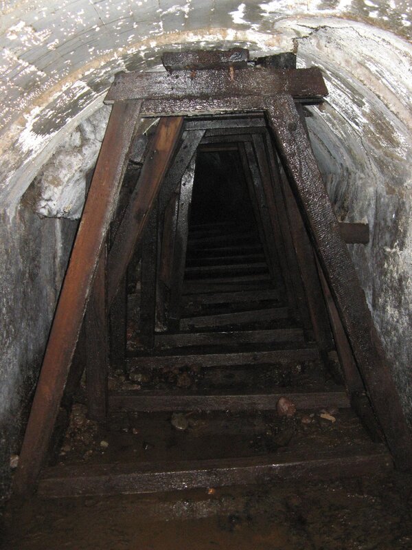 dark wooden staircase in tunnel