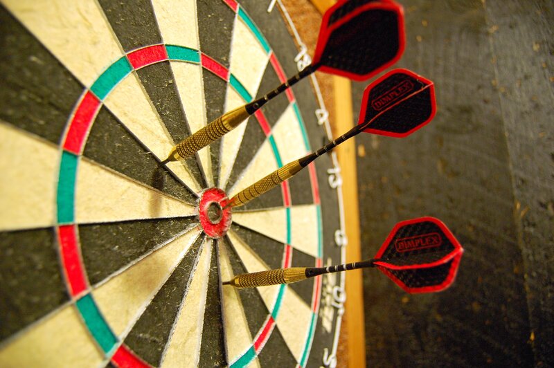 Darts hitting a dartboard