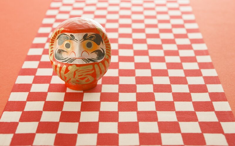 Daruma doll on checkered mat