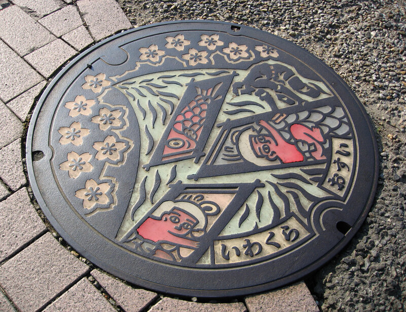 decorative manhole cover with fish and cherry blossoms
