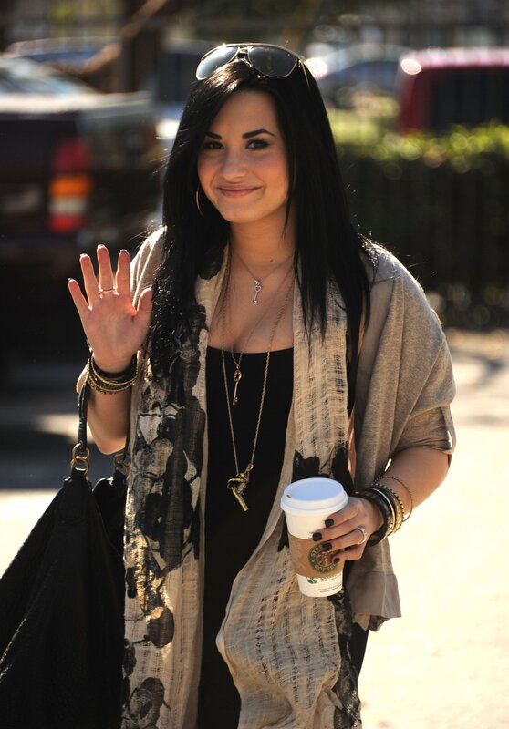Demi Lovato waving with coffee