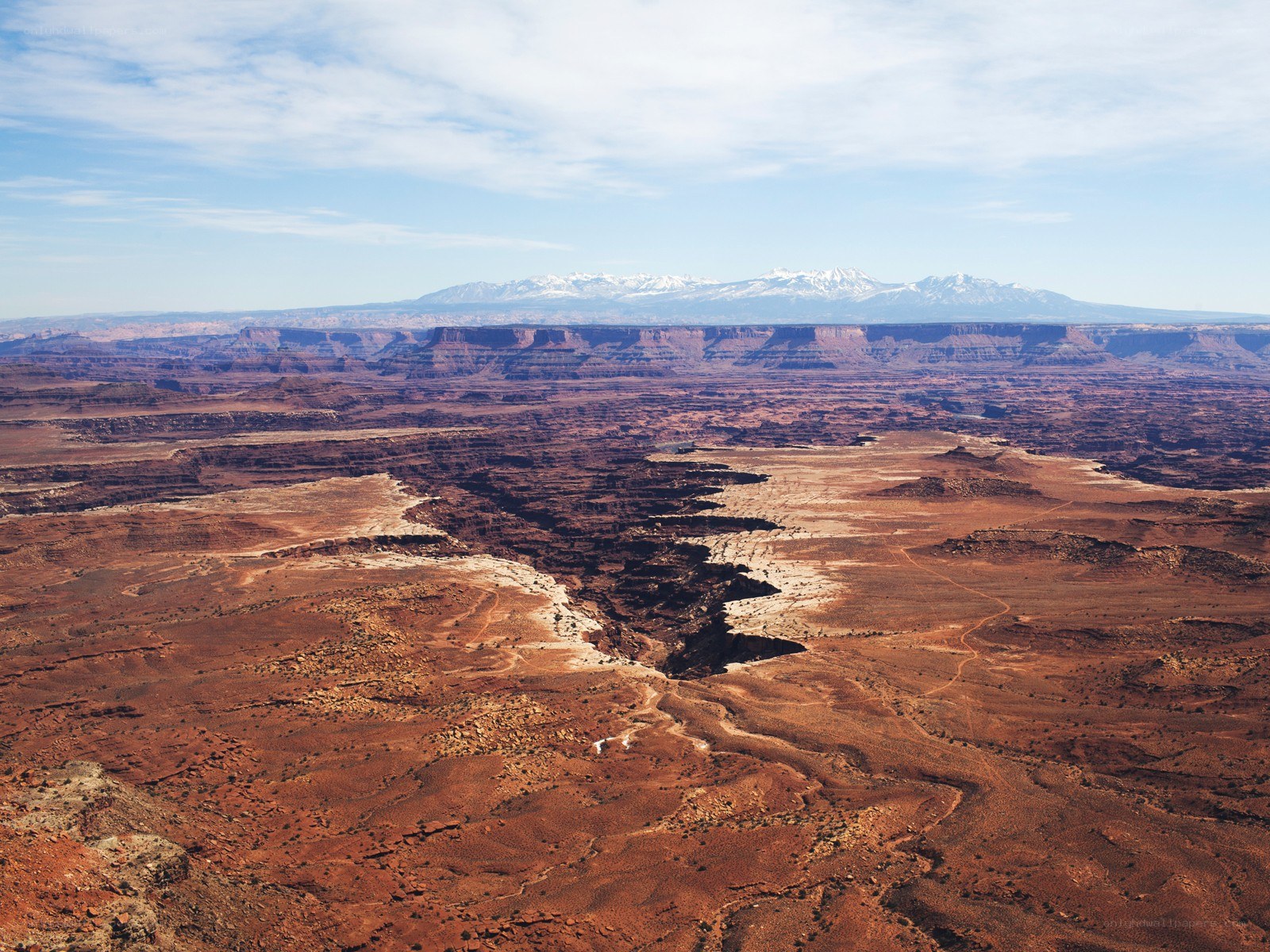 Desert canyon with snow-capped mountains