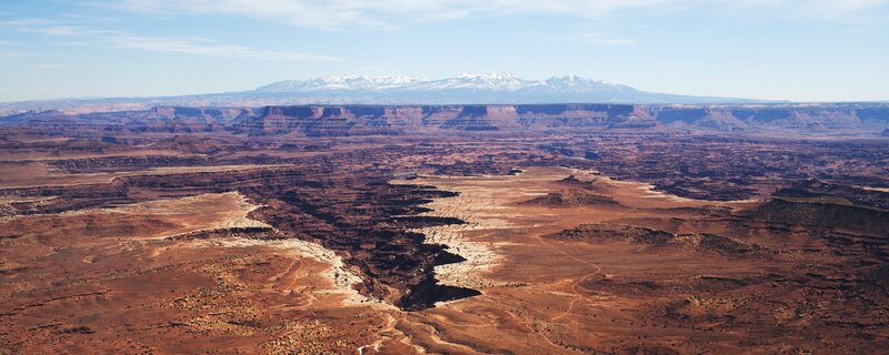 Desert canyon with snow-capped mountains