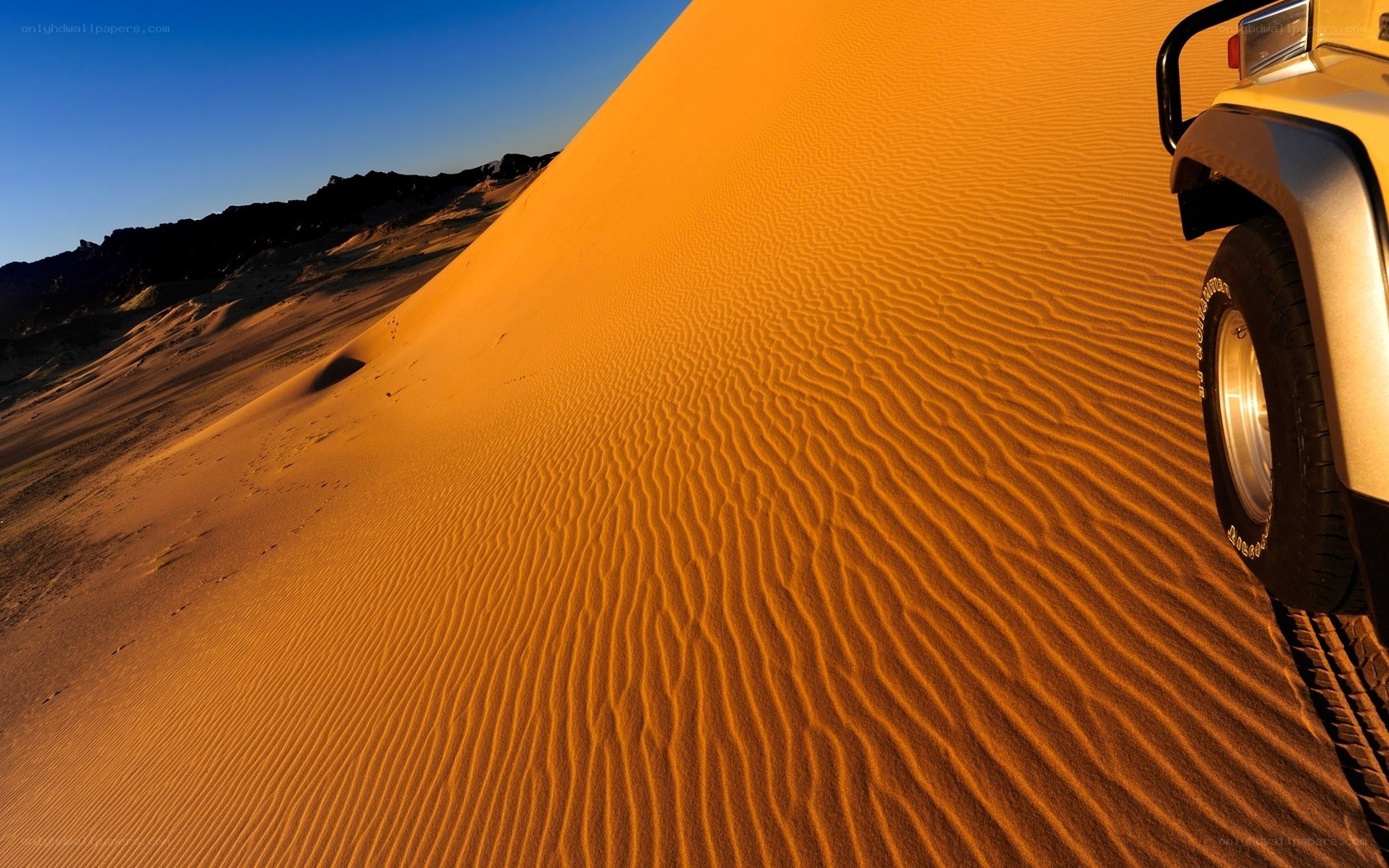 Desert dune with off-road vehicle