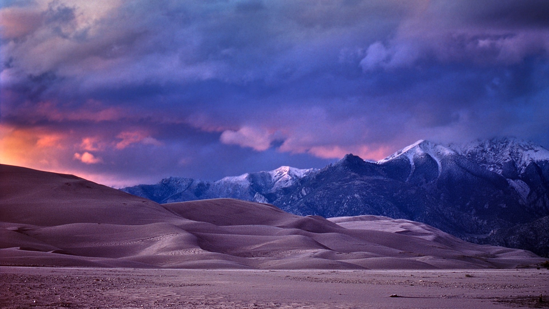 Desert dunes at sunset with mountains