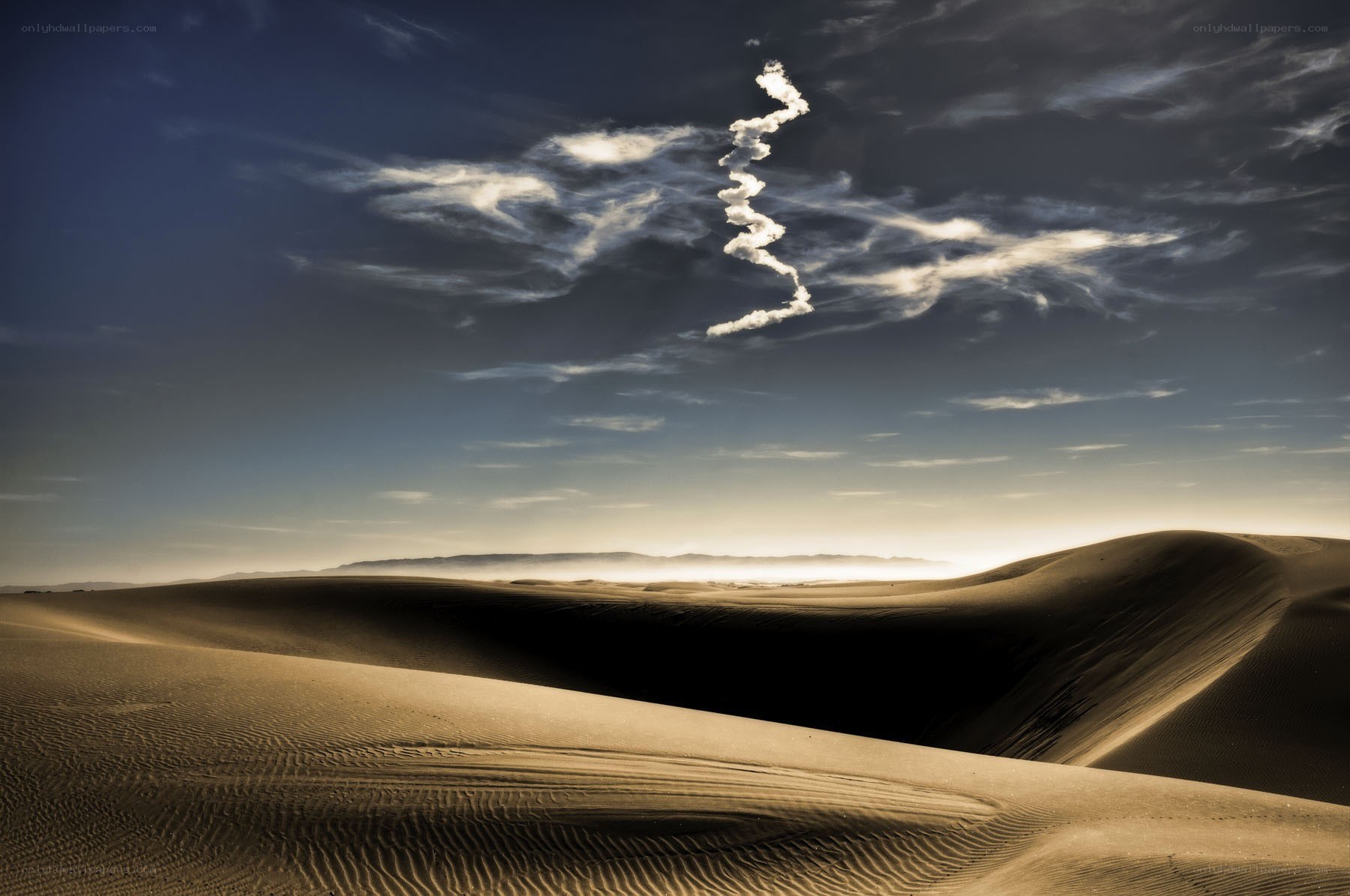 Desert dunes under a dramatic sky