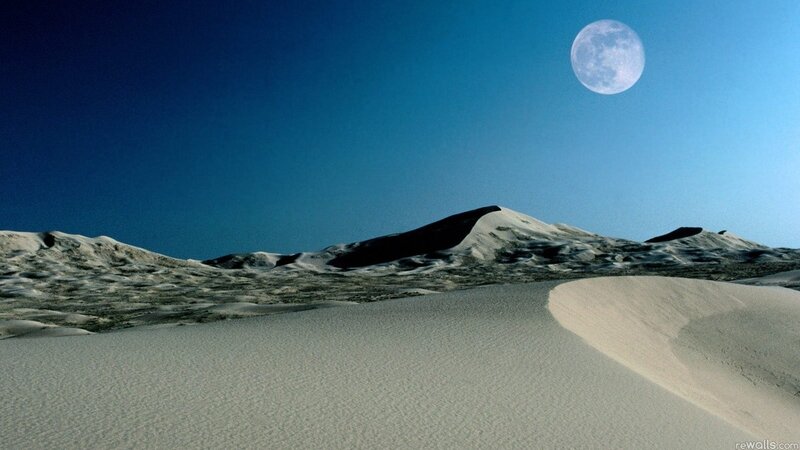 Desert dunes under a full moon