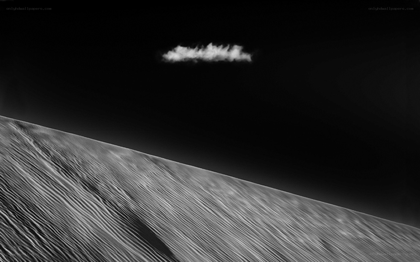 Desert dunes under a solitary cloud