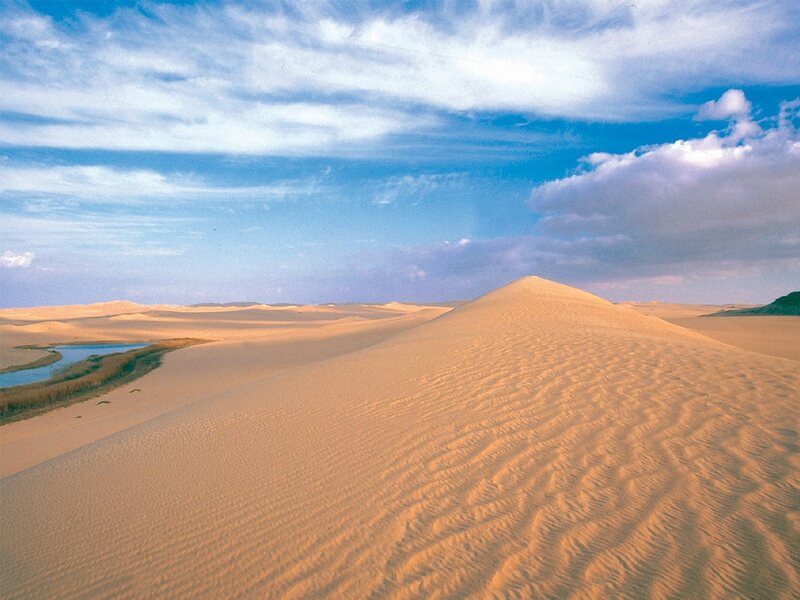 Desert dunes under blue sky