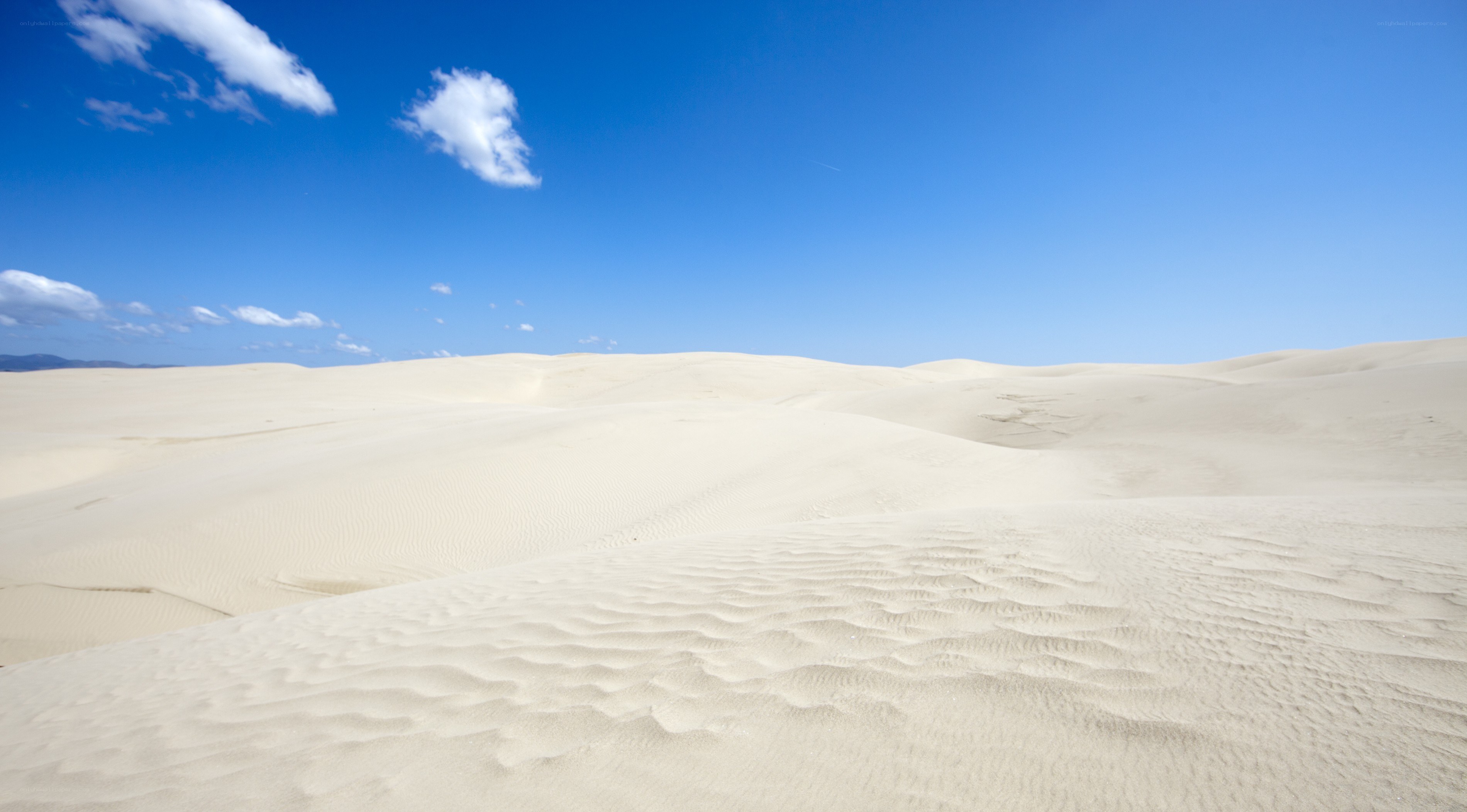 Desert dunes under blue sky