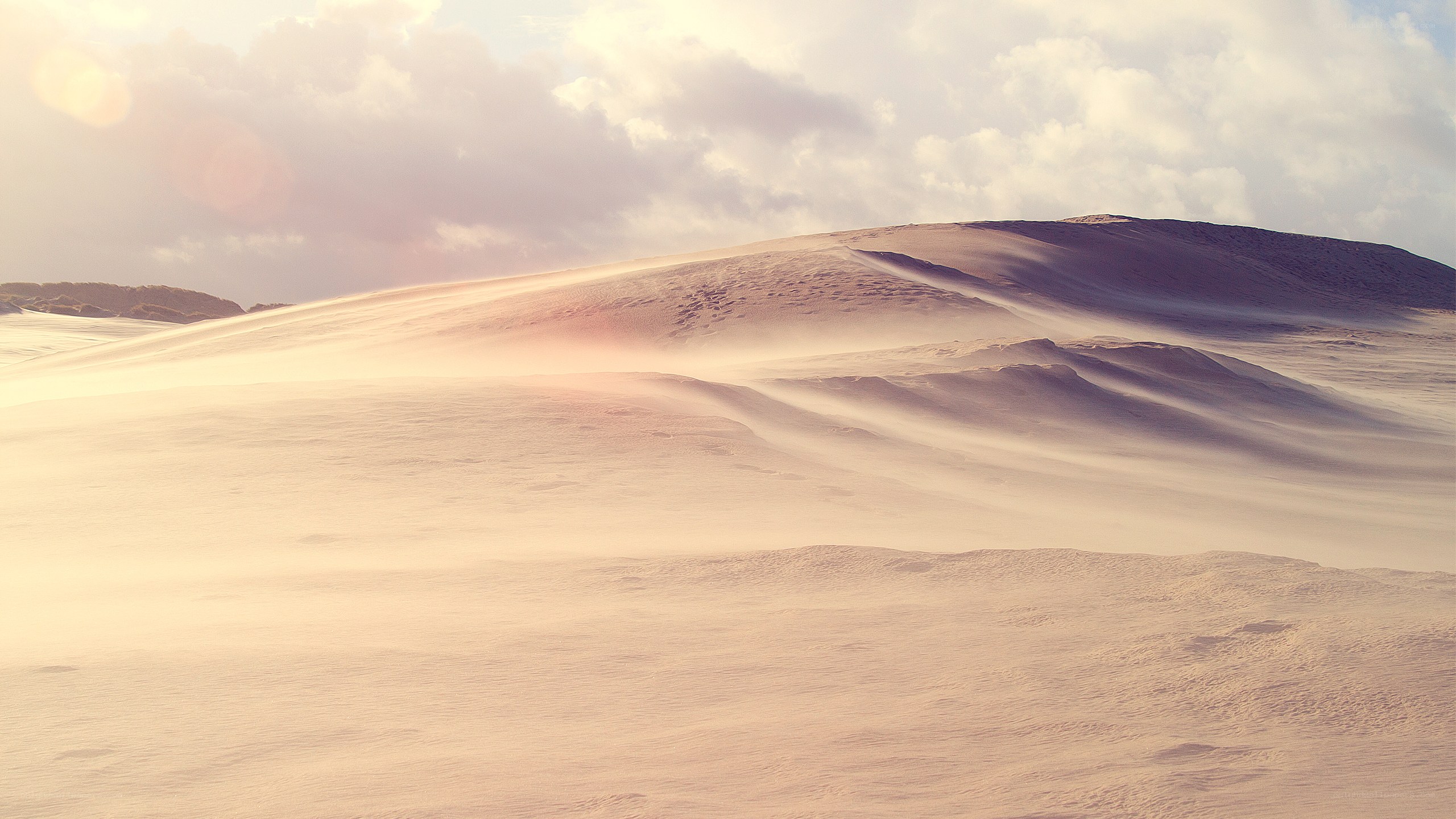 Desert dunes under cloudy sky