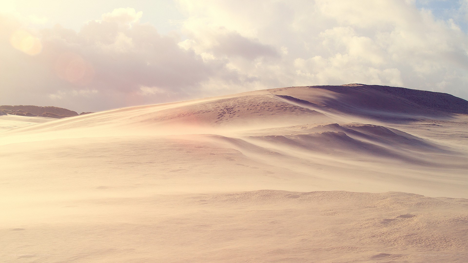Desert dunes under cloudy sky