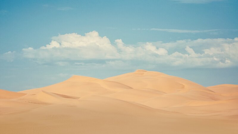 Desert dunes under cloudy sky