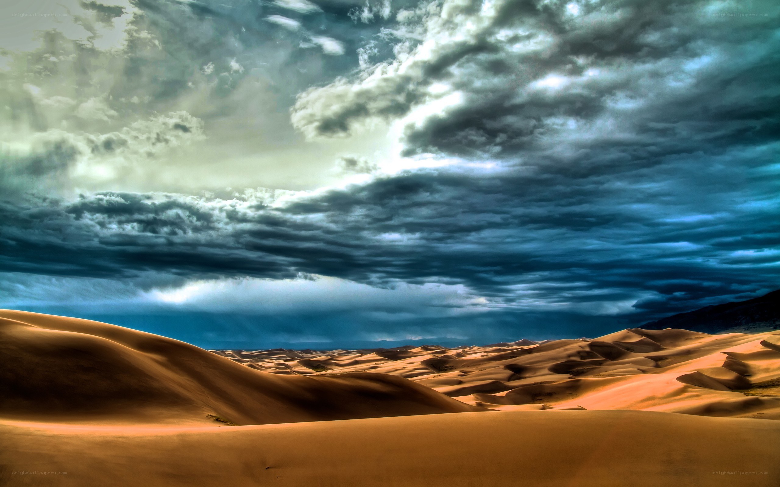 Desert dunes under stormy sky