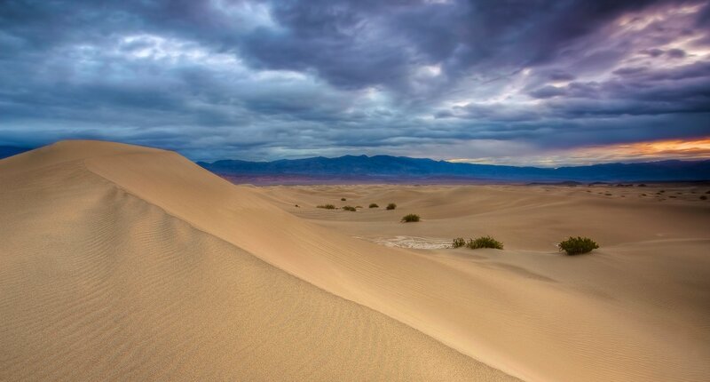 Desert dunes under stormy sky