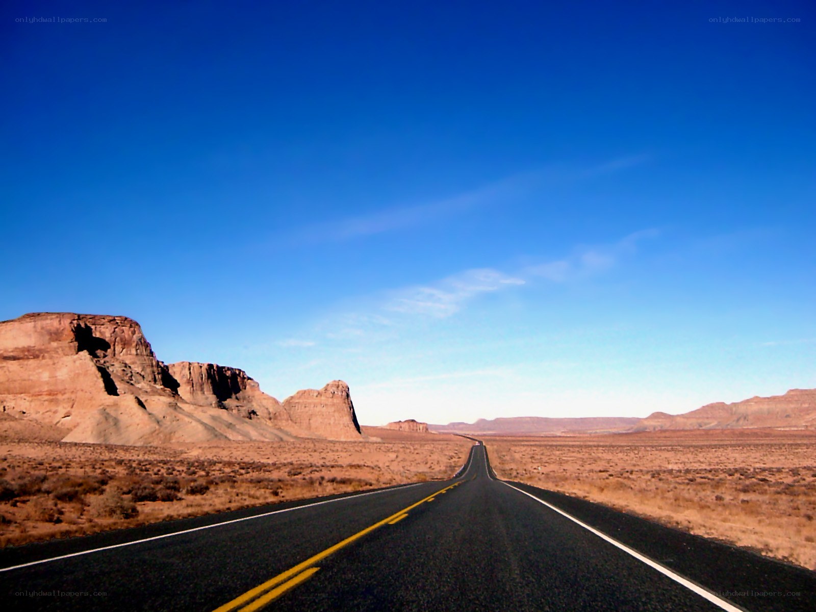 Desert highway under blue sky
