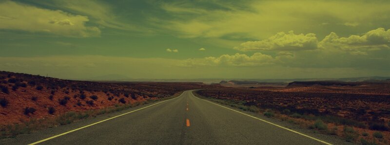 Desert highway under cloudy sky