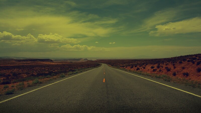 Desert highway under cloudy sky