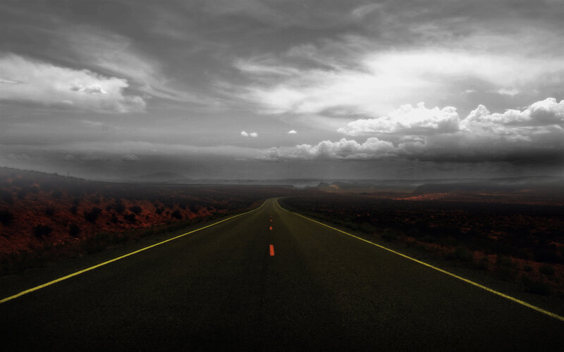 Desert highway under stormy sky