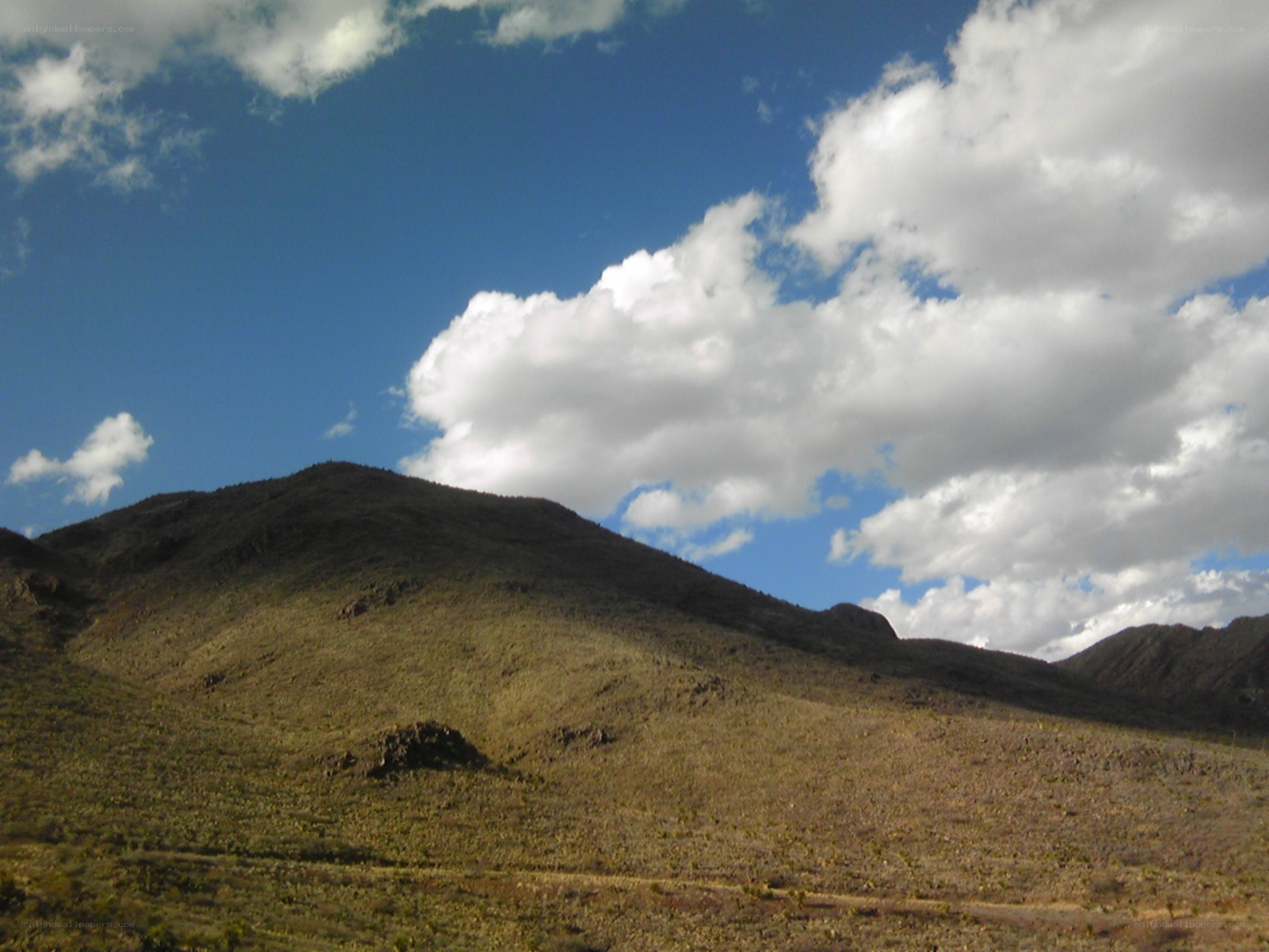 Desert mountain under cloudy sky